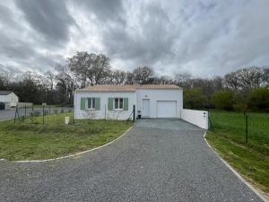 uma casa branca com uma garagem numa estrada de cascalho em Maison neuve 4 etoiles à 10 minutes de Royan 