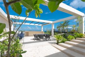 un patio con mesa y sillas. en Ceren Luxury Apartments at Fifth Avenue by Spot Rentals en Playa del Carmen