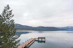 a dock on a lake with mountains in the background at Luxurious 7BR Walk 2 Beach and Bus Stop in Carnelian Bay