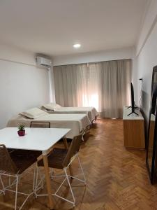 a room with four beds and a flat screen tv at Monoambiente en Abasto in Buenos Aires