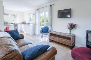 ein Wohnzimmer mit Sofa und Fernseher in der Unterkunft Skomer Lodge - 2 Bedroom Lodge - Manorbier in Manorbier