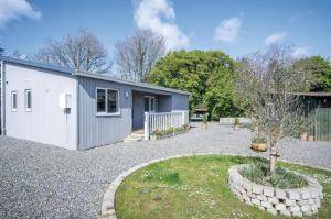 ein Schuppen mit einem Baum in einem Hof in der Unterkunft Skomer Lodge - 2 Bedroom Lodge - Manorbier in Manorbier