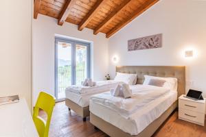 a bedroom with two beds and a desk and a window at VILLA SANT'ANNA - ALBA by Curtiaffitti in Pianello Del Lario +83 photos