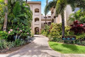 a walkway in front of a building with palm trees at The Shores at Waikoloa 231 in Waikoloa