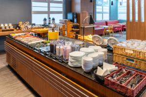 a buffet line with plates and dishes on a counter at ibis Paulinia in Paulínia