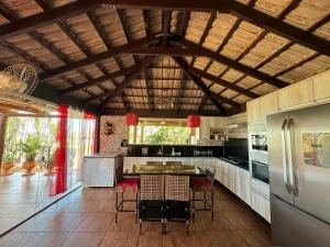 uma cozinha com um frigorífico e uma mesa com cadeiras em Rancho Flor de Iris - Lago Corumbá IV em Alexânia