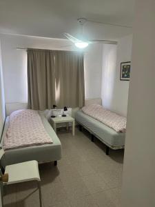 Zimmer mit 2 Betten, einem Tisch und einem Fenster in der Unterkunft Guanabara park in Puerto Rico de Gran Canaria