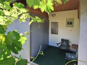 ein Außenzimmer mit einem Stuhl und einer Tür in der Unterkunft Fly & Stay Apartments in Laktaši