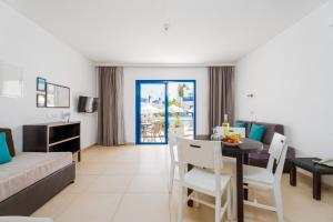 a living room with a table and a dining room at Kritamo Beach Hotel Apartments in Ayia Napa