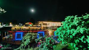 una vista de un restaurante por la noche con la luna en Houseboat Karima palace, en Srinagar
