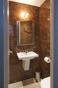 y baño con lavabo y espejo. en Linden House Hotel en Londres