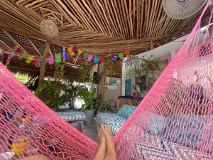a person laying in a hammock in a room at Barco Verde Hostel in Holbox Island