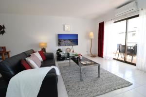 uma sala de estar com um sofá e uma mesa em Apt T2 Praia São Rafael Hibiscus 18A - Albufeira, Algarve em Albufeira
