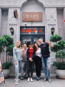 een groep mensen die voor een gebouw staan bij Riverside International Youth Hostel in Chongqing