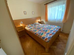 een kleine slaapkamer met een bed en een raam bij Gősy apartmanok in Siófok