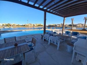 a patio with tables and chairs and a swimming pool at 3 Bedrooms villa Fanadir in Hurghada