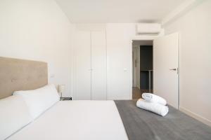 sypialnia z dużym białym łóżkiem i telefonem na podłodze w obiekcie dobohomes - Fernandez de los rios w Madrycie