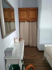 een kamer met een witte tafel met een spiegel en een bed bij Casa Las Almenillas in Antequera