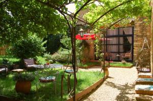 jardín con mesa y sillas y patio en La Bucolique, Chambres et Jardin d'Hôtes en Sabran