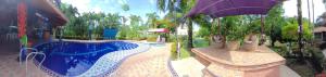 a swimming pool in a resort with an umbrella at cabaña La Alejandra in Villavicencio