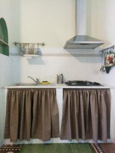 eine Küche mit Spüle und Herd in der Unterkunft Casa Vacanze Nonna Vincenza in Neviano