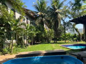 uma casa com piscina no quintal em Rio Natureza apart 113 no Rio de Janeiro