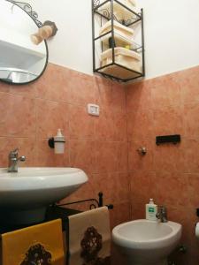 ein Badezimmer mit Waschbecken, Toilette und Spiegel in der Unterkunft Casa Vacanze Nonna Vincenza in Neviano