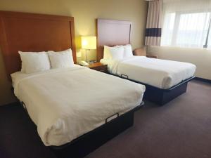 two beds in a hotel room with white sheets at Comfort Inn & Suites Madison - Airport in Madison