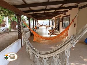 a hammock on the porch of a house at Hotel Safari Club Robore in Roboré