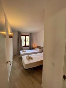 a room with two beds and a window at Casa Sasera in Colonia Sant Jordi