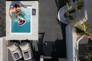 an overhead view of a woman in a swimming pool at Aja Retreat Luxury Suites in Kamari