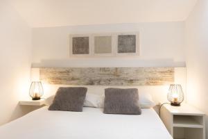 a bedroom with a white bed with two pillows at Torrontero con vistas al mar in Bermeo