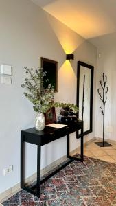 une table noire avec un vase de fleurs sur elle dans l'établissement Casa da Bertu, à Barbaresco