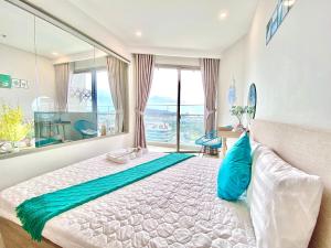 a bedroom with a large bed with a large window at The Sóng Vũng Tàu - An Gia Apartment in Vung Tau