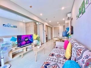 a living room with a couch and a tv at The Sóng Vũng Tàu - An Gia Apartment in Vung Tau