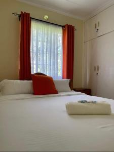 um quarto com uma grande cama branca e uma janela em Rockerz Grill B&B em Nairobi