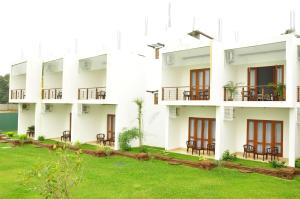 an image of a building with chairs and grass at Ruins Chaaya Hotel in Polonnaruwa