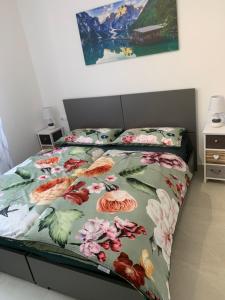 a bedroom with a bed with a floral comforter at Appartamenti Estera 2 in Malcesine