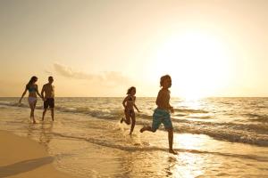 un grupo de personas corriendo por la playa en Dreams Sapphire Resort & Spa, en Puerto Morelos