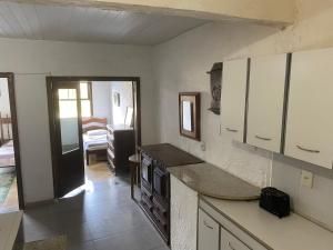 uma cozinha com armários brancos e uma bancada em Rio Natureza apart 113 no Rio de Janeiro