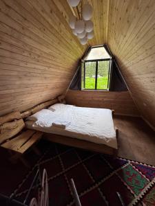 Bett in einem Holzzimmer mit Fenster in der Unterkunft Super View-2 Bedroom Chalet Karakol in Karakol