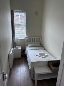 een kleine slaapkamer met een bed en een raam bij Superb Location 3 MIN TO RDS, AVIVA, D4 2 BED APARTMENT in Dublin