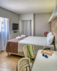 une chambre d'hôtel avec un lit, une table et des chaises dans l'établissement Hotel Costamar Ponta Verde, à Maceió