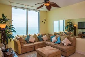 a living room with a large couch with pillows at 1801 Sapphire Beachfront 3 Bedroom Condo in South Padre Island