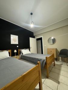 una camera d'albergo con due letti e una sedia di DreamCoast Apartments I a Artemida