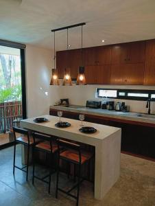 a kitchen with a island with chairs and a table at Agua & Selva luxury Jungle loft in Tulum
