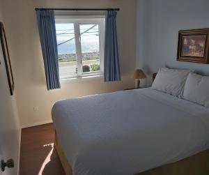 um quarto com uma cama grande e uma janela em Heron's Landing Hotel em Campbell River