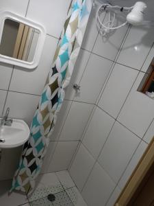 a bathroom with a shower and a sink at Casinha Vó Cidinha in Aparecida