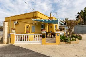 ein gelbes Haus mit einem Tisch und einem Zaun in der Unterkunft Casa Marti i Carmeta in Deltebre