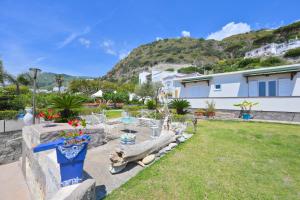 a yard with a house and a mountain at Blu Maronti in Ischia